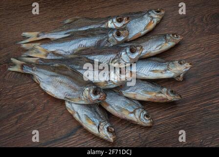 quelques poissons séchés sur un fond en bois foncé/ Banque D'Images