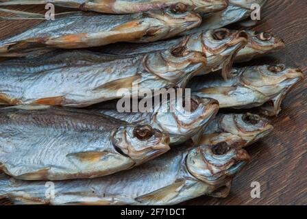 quelques poissons séchés sur un fond en bois foncé/ Banque D'Images