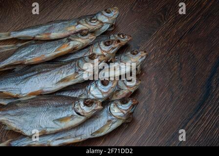 quelques poissons séchés sur un fond en bois foncé/ Banque D'Images