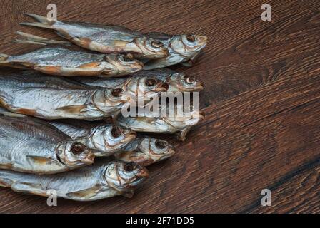 quelques poissons séchés sur un fond en bois foncé/ Banque D'Images