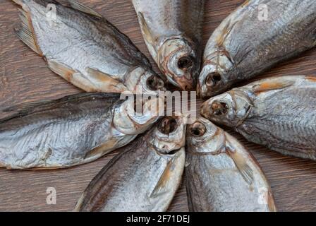 quelques poissons séchés sur un fond en bois foncé/ Banque D'Images