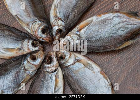 quelques poissons séchés sur un fond en bois foncé/ Banque D'Images