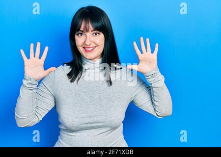 Jeune femme hispanique portant des vêtements décontractés montrant et pointant vers le haut avec les doigts numéro dix tout en souriant confiant et heureux. Banque D'Images