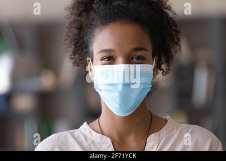 Portrait d'une femme biraciale souriante dans un masque facial Banque D'Images