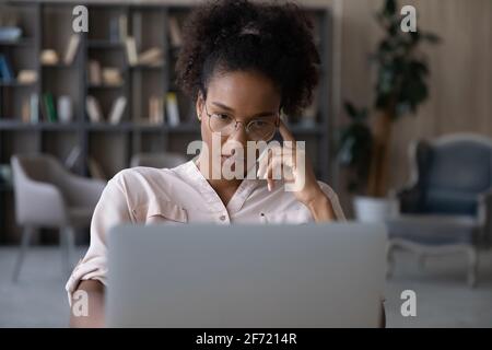 Une femme biraciale pensive travaille sur la pensée d'un ordinateur portable Banque D'Images