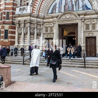 Londres, Royaume-Uni. 4th avril 2021. Congrégation sortant de la cathédrale de Westminster, Londres, après la messe du dimanche de Pâques de 10am célébrée par les catholiques romains. Les aumôniers de la cathédrale accueillent et bénissent les paroissiens. Banque D'Images