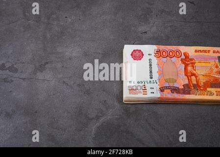 Le russe rousse un gros lot sur fond gris. Un paquet de cinq mille roubles notes. Place pour le logo, le texte, la mise en page, la maquette. Banque D'Images