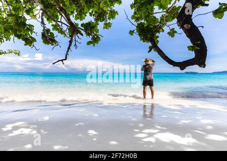 Belle plage de sable et un homme touriste prendre une photo avec vague aux îles Similan, belle île tropicale de la Thaïlande. Banque D'Images