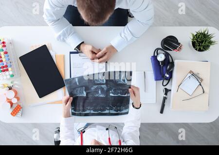 Le médecin et le patient discutent de l'image radiologique à la table de travail Banque D'Images