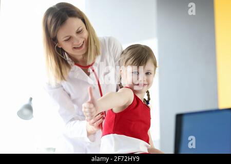 Le médecin pédiatre écoute le souffle de la petite fille à travers le stéthoscope Banque D'Images