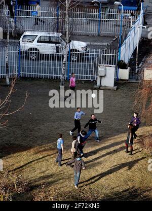 Des enfants jouent au football dans l'arrière-cour de l'ONU, à Pristina, la capitale du Kosovo. Banque D'Images