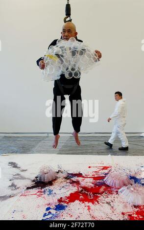 L'ARTISTE JAPONAIS VÉTÉRAN SHOZO SHIMAMOTO EST SUSPENDU DANS LES AIRS EXÉCUTION D'UNE NOUVELLE VERSION DE SON TRAVAIL SÉMINAL 'LANCEMENT DE BOUTEILLE ARTT'.19 OCTOBRE 2001 PHOTO ANDY PARADISE Banque D'Images