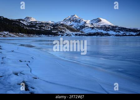 Lever de soleil en hiver au lac Bouillouses. En arrière-plan, pics périques (Cerdagne, Pyrénées Orientales, Occitanie, France) Banque D'Images