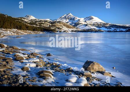 Lever de soleil en hiver au lac Bouillouses. En arrière-plan, pics périques (Cerdagne, Pyrénées Orientales, Occitanie, France) Banque D'Images