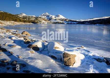 Lever de soleil en hiver au lac Bouillouses. En arrière-plan, pics périques (Cerdagne, Pyrénées Orientales, Occitanie, France) Banque D'Images