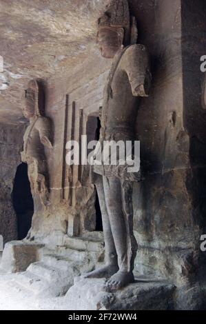 Deux statues géantes du dieu hindou Shiva debout côté de l'entrée de l'autel dans l'un des Les temples grottes sur l'île Elephanta au large des coias Banque D'Images