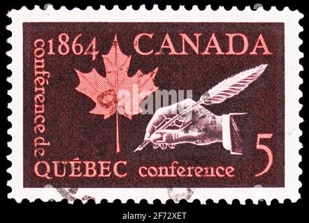 MOSCOU, RUSSIE - le 12 JANVIER 2021 : le timbre-poste imprimé au Canada montre la feuille d'érable et la main avec Quill Pen, série de la Conférence du Centenaire du Québec, cir Banque D'Images