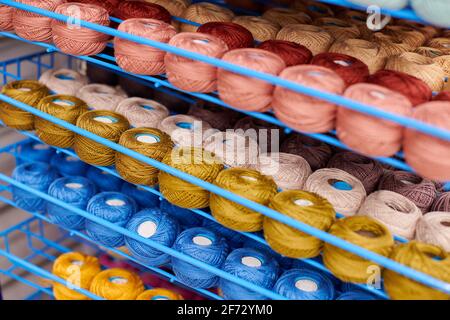 Des fils ou des balles de laine sur les étagères en magasin pour le tricotage et la couture. Accessoires pour la mercerie dans les étagères des magasins de tissus. Image multicolore, ba Banque D'Images