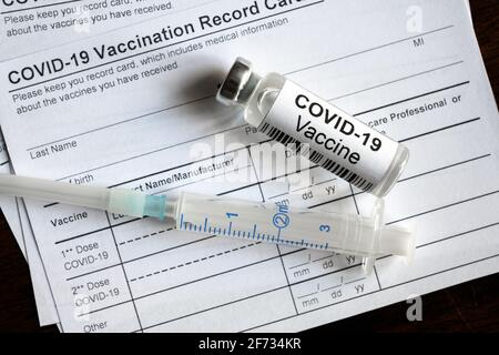 Le flacon et la seringue de vaccin COVID-19 sont sur la carte de vaccination du coronavirus, formulaire médical requis pour le voyage. Concept de certificat de vaccination, Banque D'Images