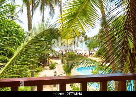 Hôtel ou maison résidentielle dans un jardin tropical, terrasse donnant sur la plage ensoleillée et la piscine, Sri Lanka. Vue sur la mer depuis le balcon de la maison. Vue sur l'océan Banque D'Images