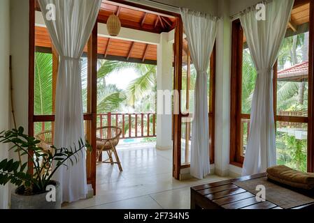 Tangalle, Sri Lanka - 2 novembre 2017: Hôtel ou maison résidentielle dans le jardin tropical, chambre avec terrasse, fenêtres et vue sur la plage. Intérieur intérieur à Indi Banque D'Images