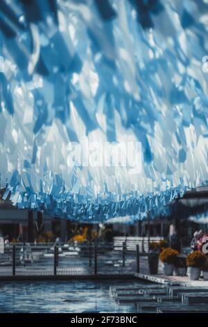 Une vue verticale d'une zone publique urbaine avec du bleu et des bandes blanches accrochées du dessus d'une piscine au carrelage bleu dans le fond et le pont dans un dos défoqué Banque D'Images