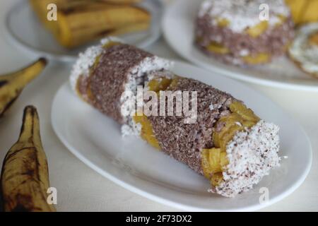 Gâteau de farine de millet à la vapeur avec une généreuse couche de noix de coco fraîche entre les deux. Connu localement sous le nom de Ragi puttu. Servi avec du plantain à la vapeur. Prise de vue activée Banque D'Images