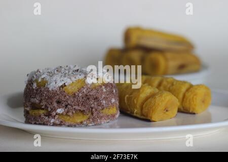 Gâteau de farine de millet à la vapeur avec une généreuse couche de noix de coco fraîche entre les deux. Connu localement sous le nom de Ragi puttu. Servi avec du plantain à la vapeur. Prise de vue activée Banque D'Images