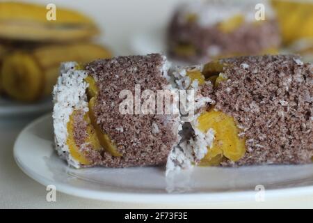 Gâteau de farine de millet à la vapeur avec une généreuse couche de noix de coco fraîche entre les deux. Connu localement sous le nom de Ragi puttu. Servi avec du plantain à la vapeur. Prise de vue activée Banque D'Images