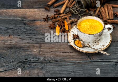 Boisson chaude au curcuma avec épices sur fond de bois rustique Banque D'Images