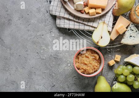 Confiture de poires savoureuse avec différents fromages sur fond de grunge Banque D'Images