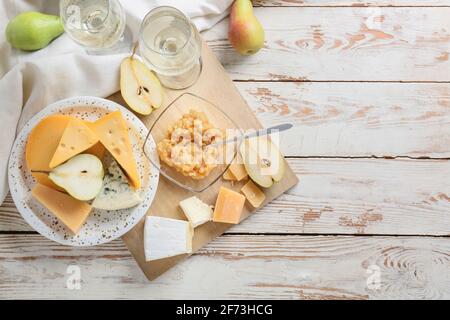 Confiture de poires savoureuse avec différents fromages et vin sur blanc arrière-plan en bois Banque D'Images