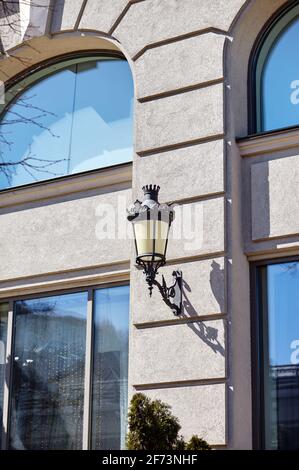 Ancienne lampe de rue en fer forgé noir sur le mur. Lampadaire noir rétro décoratif suspendu à la façade Banque D'Images