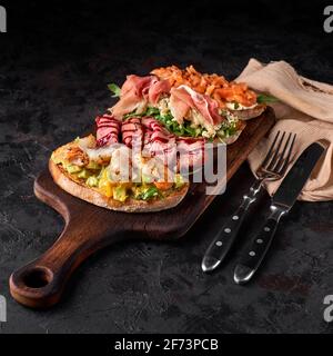 panneau en bois avec de savoureux bruschettas frais sur la table Banque D'Images