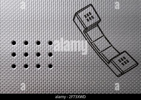 La texture, l'arrière-plan, le papier peint de l'interphone et son pochoir sur le mur gris en métal ondulé Banque D'Images