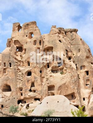 Anciennes grottes résidentielles creusées et sculptées dans le passé par les habitants des régions montagneuses de la Cappadoce sur la toile de fond d'un ciel bleu. Banque D'Images