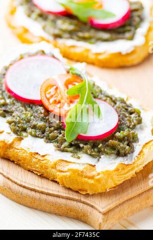 Sandwiches végétaliens avec crème d'avocat. Sandwichs sains avec fromage à la crème, avocat, radis et tomates cerises Banque D'Images