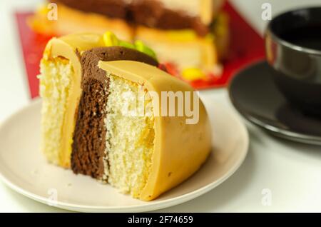 Morceau du gâteau Burger, gâteau de Madère et de l'éponge de chocolat, rempli de glaçage recouvert de glaçage doux et de décorations de sucre comestible, gâteau i Banque D'Images