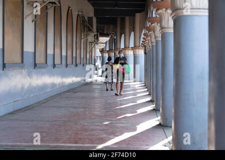 Une scène de rue capturée tôt le matin en tant que gens promenez-vous dans une colonnade éclairée par le soleil Banque D'Images