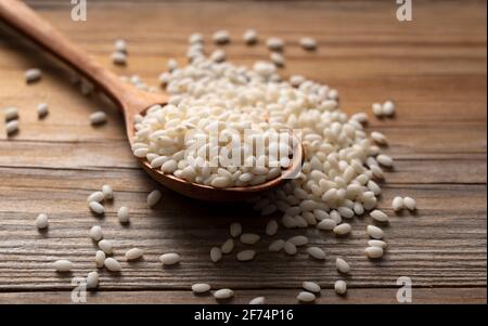 Riz gluant et cuillère en bois placée sur un fond en bois. Vue en gros plan réelle Banque D'Images