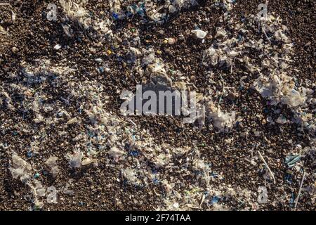 Petites pièces en plastique et microplastiques sur la plage de sable Banque D'Images