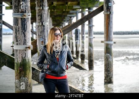 Élégante et bien habillée, cette femme d'âge moyen est située sous le plus long quai du Canada, le White Rock Pier, d'une longueur de 470 mètres, en Wh Banque D'Images