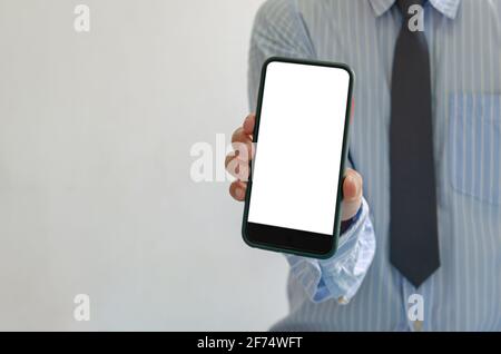 homme tient un smartphone à la main. Maquette de téléphone mobile écran blanc blanc se tenant contre. Utilisation pour la publicité de marketing ou la promotion en ligne de produit.CLI Banque D'Images