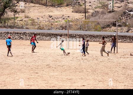 Des garçons locaux jouant au football ou au football sur un terrain de football de base sur l'île rodrigues, dans l'océan indien, à l'île maurice Banque D'Images