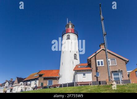 Phare blanc et maisons sur le haut de la digue à Urk, Pays-Bas Banque D'Images