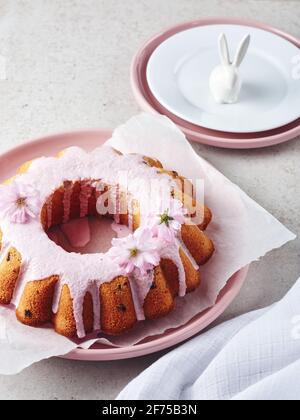 Gâteau de fête avec glaçage rose et fleurs de cerise. Banque D'Images