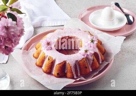 Gâteau de fête avec glaçage rose et fleurs de cerise. Banque D'Images