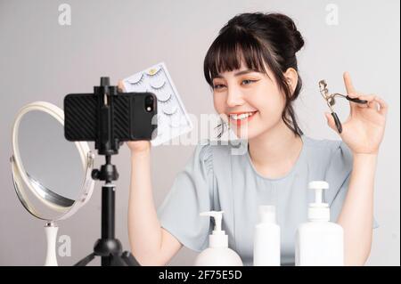 Jeune femme asiatique en direct streaming à l'enseignement maquillage en ligne Banque D'Images