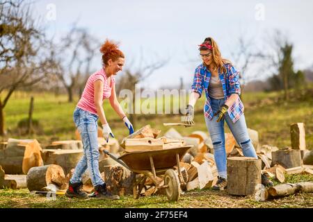 deux femmes travaillent ensemble pour mettre du bois de chauffage pour l'hiver Banque D'Images