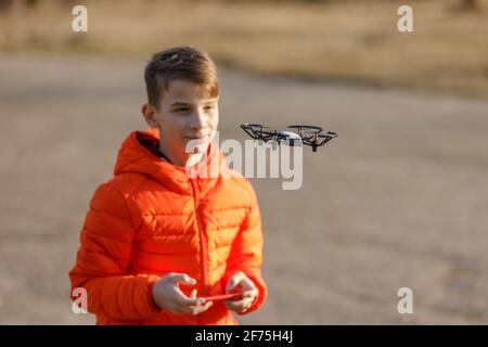 Un adolescent volant un petit drone dans le parc Banque D'Images